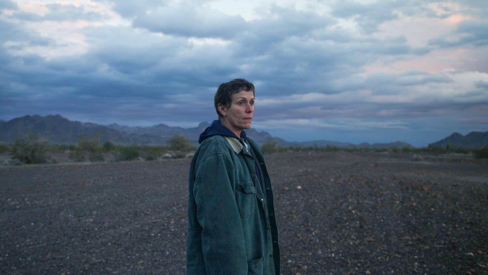 Blick in eine ungewisse Zukunft: Frances McDormand im Fillm Nomadland. Im Hintergrund ist der weite Himmel zu sehen, eine Frau blickt aus dem Bild heraus in die Ferne. Blick in eine ungewisse Zukunft: Frances McDormand im Fillm Nomadland. Im Hintergrund ist der weite Himmel zu sehen, eine Frau blickt aus dem Bild heraus in die Ferne.