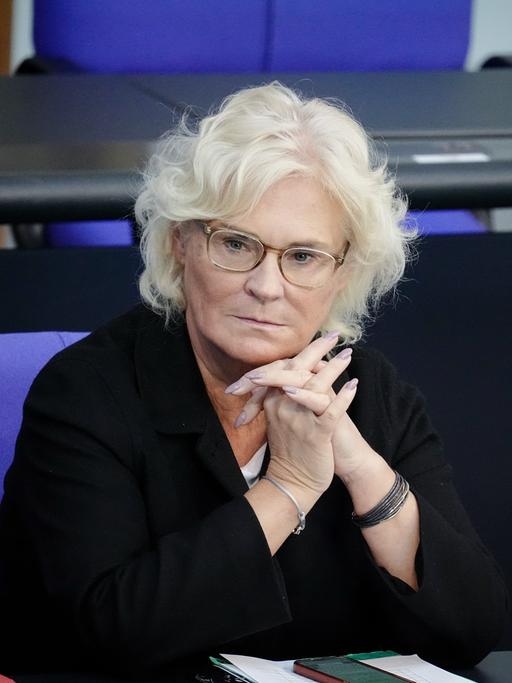 Christine Lambrecht, den Kopf auf die gefalteten Hände gestützt, sitzt nachdenklich, alleine in einer Bank im Bundestag.