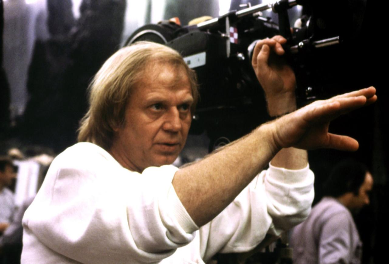 Der Regisseur Wolfgang Petersen, neben einer großen Filmkamera, gibt Handzeichen in Richtung der Schauspieler. Der Regisseur Wolfgang Petersen, neben einer großen Filmkamera, gibt Handzeichen in Richtung der Schauspieler.