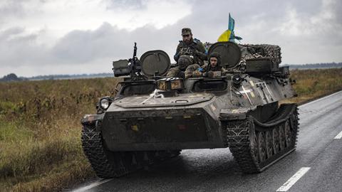 Ukrainische Soldaten mit Flagge in einem Panzer, den Russen zurückgelassen haben. Izium, Kharkiv, 14. September 2022. 