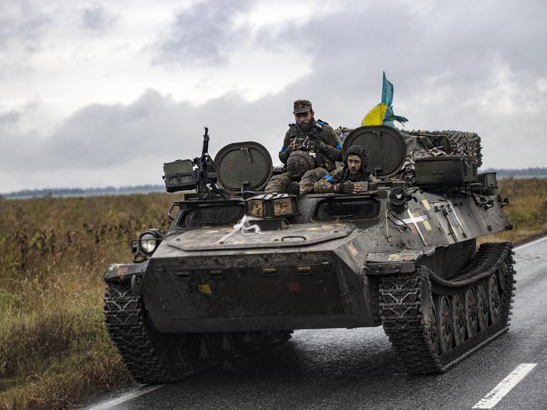Ukrainische Soldaten mit Flagge in einem Panzer, den Russen zurückgelassen haben. Izium, Kharkiv, 14. September 2022. 