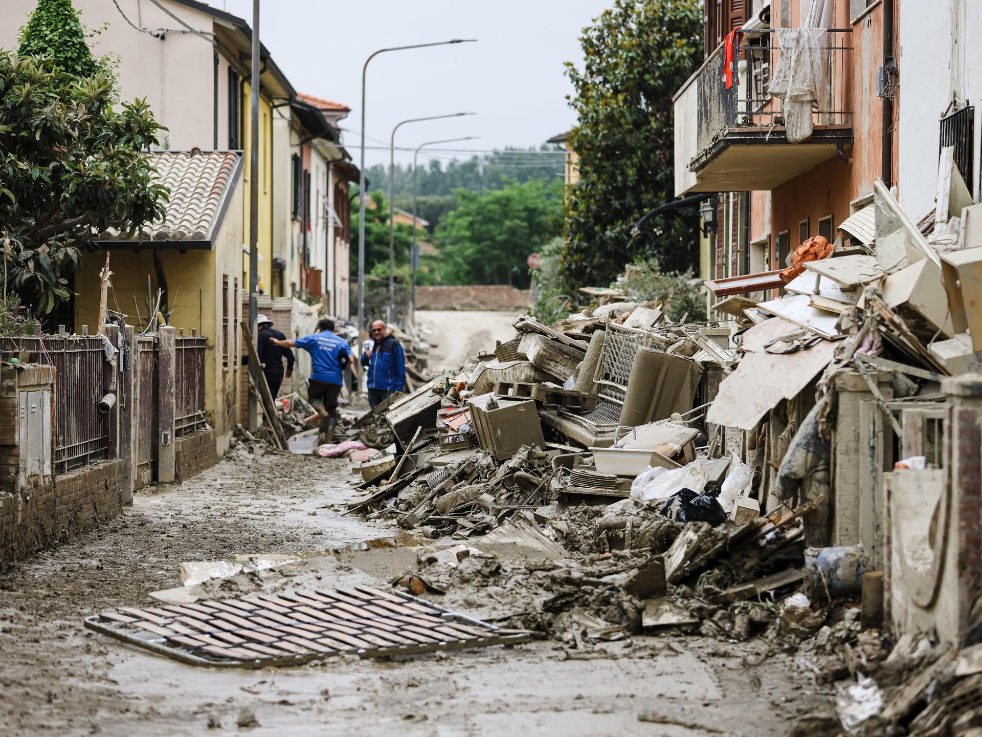 Schlammige Gegenstände türmen sich in einer Straße: Flutschäden in der norditalienischen Stadt Faenza.
