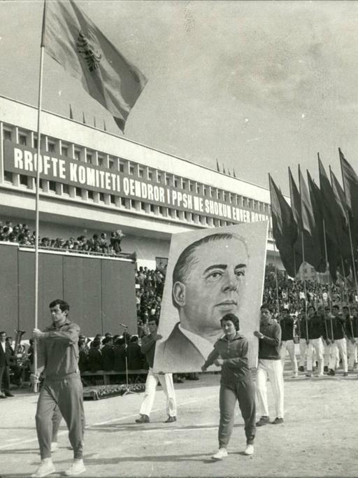 Historische Aufnahme aus Dezember 1977: Studenten marschieren mit Fahnen zur Feier des 20-jährigen Bestehens der Universität Tirana. Zwei Männer tragen zudem ein großes Plakat mit dem Konterfei von Enver Hoxha, dem damaligen kommunistischen Herrscher Albaniens.