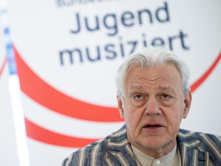 Das Bild zeigt Ulrich Rademacher, im Hintergrund der Schriftzug "Jugend musiziert".