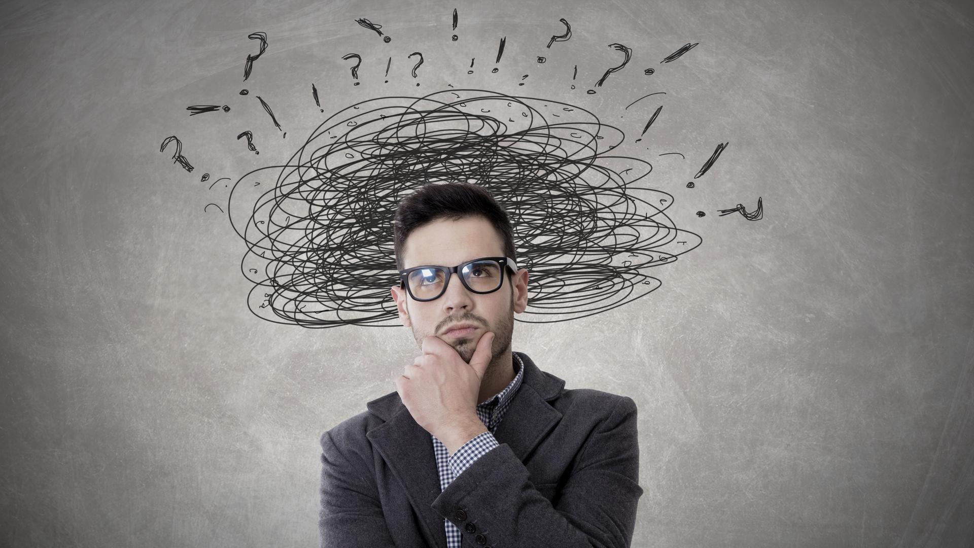 Ein Mann im Anzug mit Zeichnungen über dem Kopf, die Stress abbilden sollen. Ein Mann im Anzug mit Zeichnungen über dem Kopf, die Stress abbilden sollen.