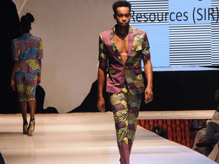 Die Lagos Fashion Week im Jahr 2016. Zu sehen: Ein modisch gekleideter junger Mann geht über den Laufsteg. 