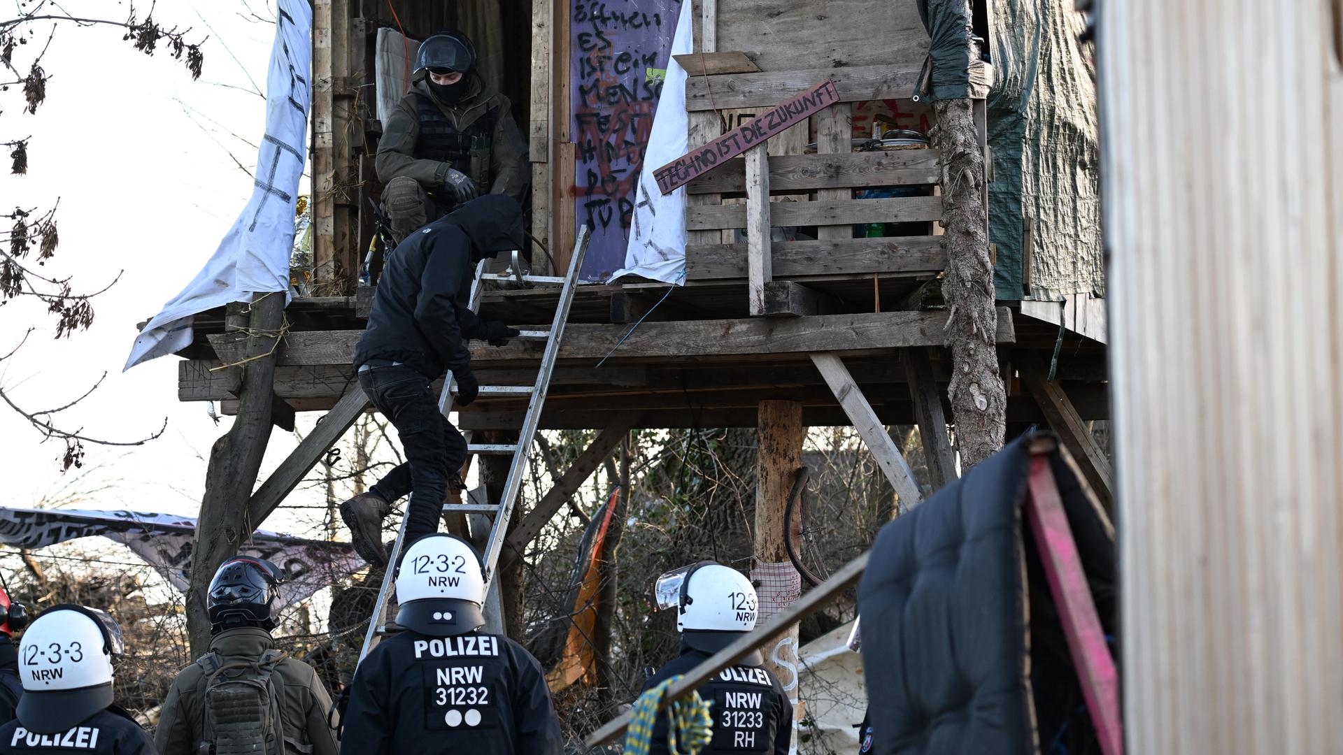 Ein Klimaaktivist verlässt ein Baumhaus in Lützerath, nachdem es von der Polizei göffnet worden ist.