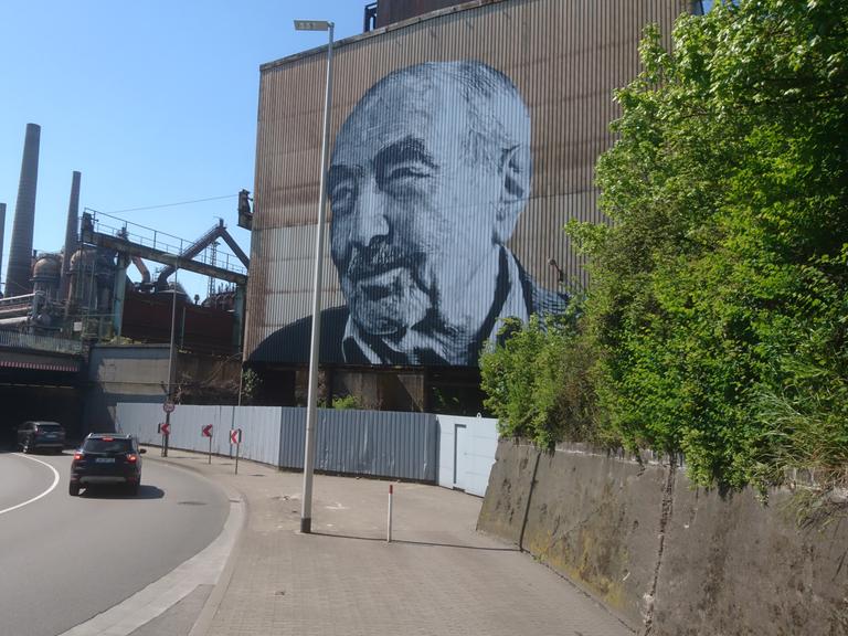  Monumentale Kunst von Hendrik Beikirch: Das gespraytes Bild zeigt den türkische Arbeiter Kaya Urhan an einer Fassade