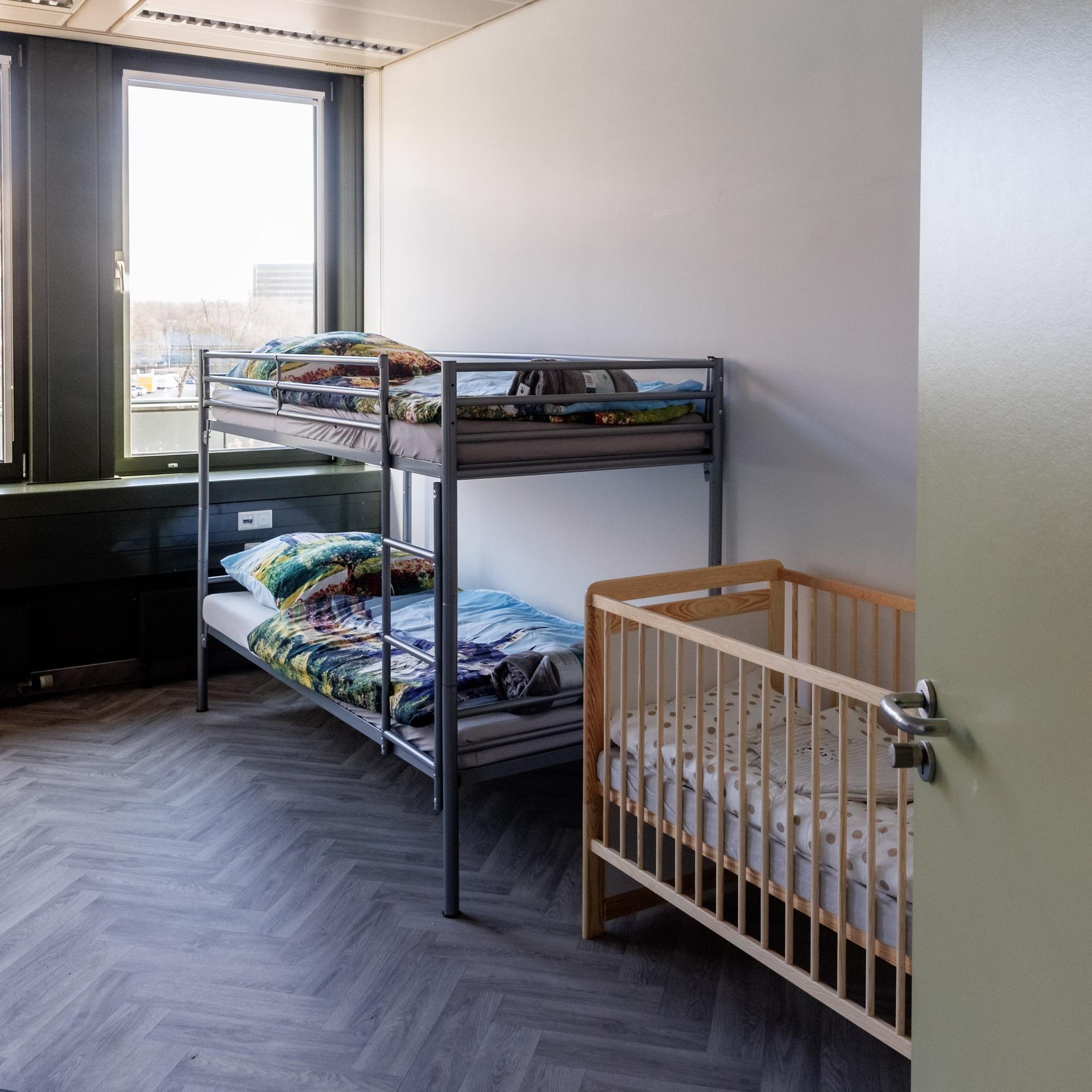 Blick in einen für Flüchtlinge eingerichteten Wohnraum mit einem Stockbett und einem Kinderbett. 