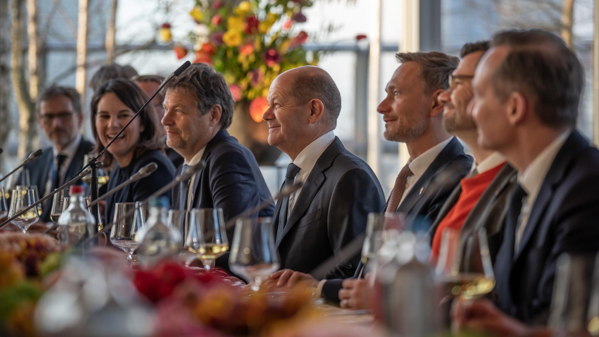 Bundeskanzler Olaf Scholz sitzt unter anderem mit den Ministern Robert Habeck und Christian Lindner an einem großen Tisch. 