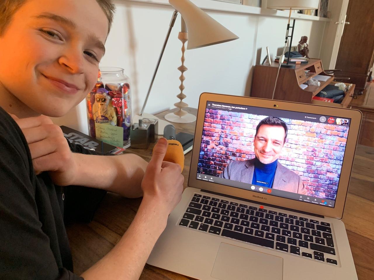 Reporter-Kind Lasse sitzt grinsend und den Daumen nach oben zeigend vor einem Laptop. Auf dem Bildschirm ist der Gedankenleser Thorsten Havener zu sehen.