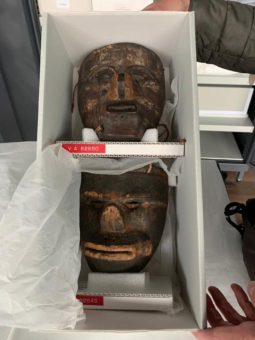 Hölzerne Gesichtsmasken in einer Aufbewahrungsbox.
