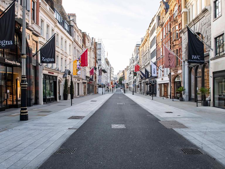 Symmetrische Ansicht der menschenleeren Bond Street mit geschlossenen Geschäften.