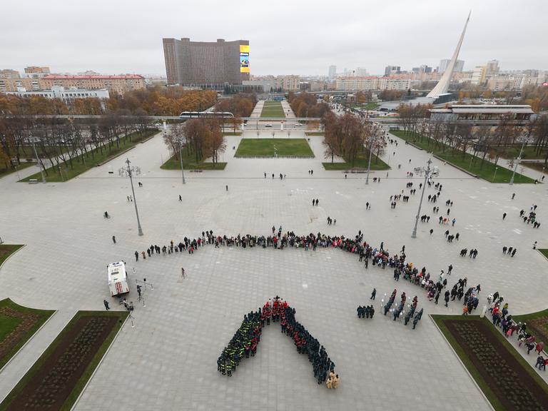 Moskauer Passanten betrachten einen Festakt der Feuerwehr zum "Tag der Einheit des Volkes" auf dem Ausstellungsgelände "Errungenschaften der Volkswirtschaft".