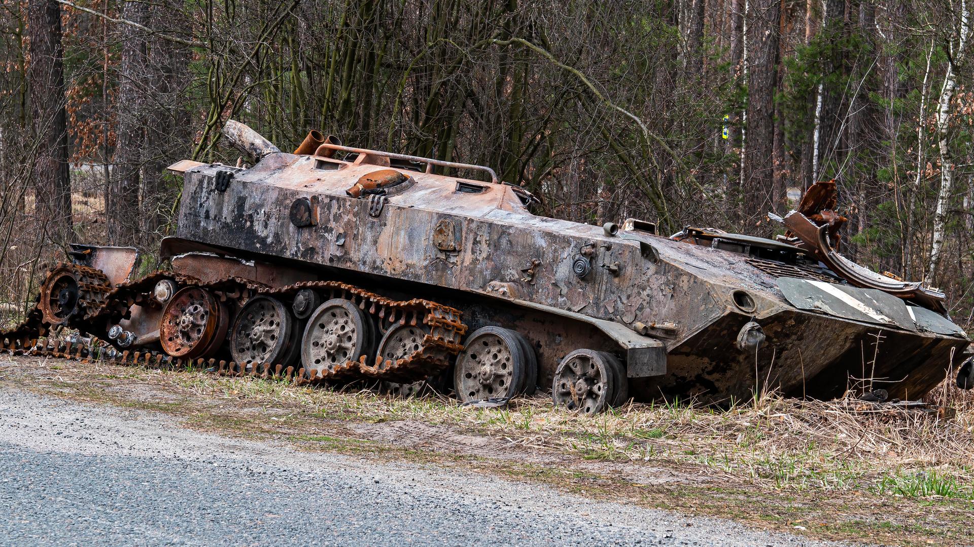 Ein zerstörter russischer Schützenpanzer auf einer Straße in der Ukraine