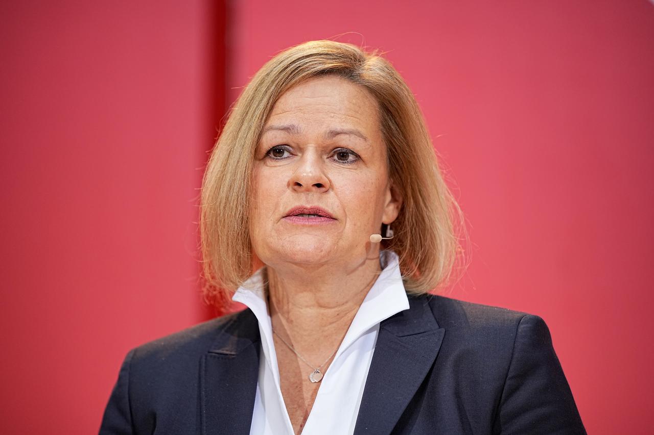 Nancy Faeser mit dunklem Jackett und weißem Hemd vor einer roten Wand. Nancy Faeser mit dunklem Jackett und weißem Hemd vor einer roten Wand.