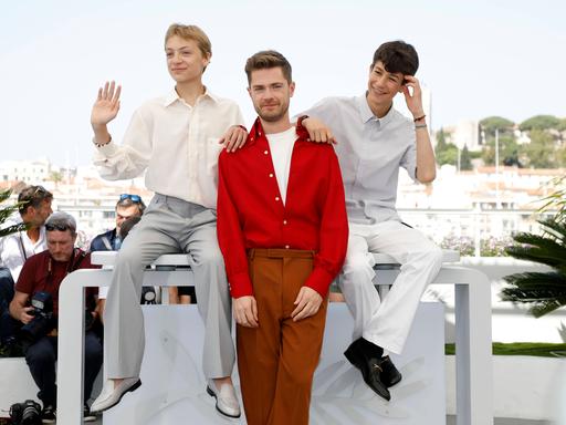 Eden Dambrine, Lukas Dhont und Gustav De Waele stehen in Cannes bei einem Fototermin.