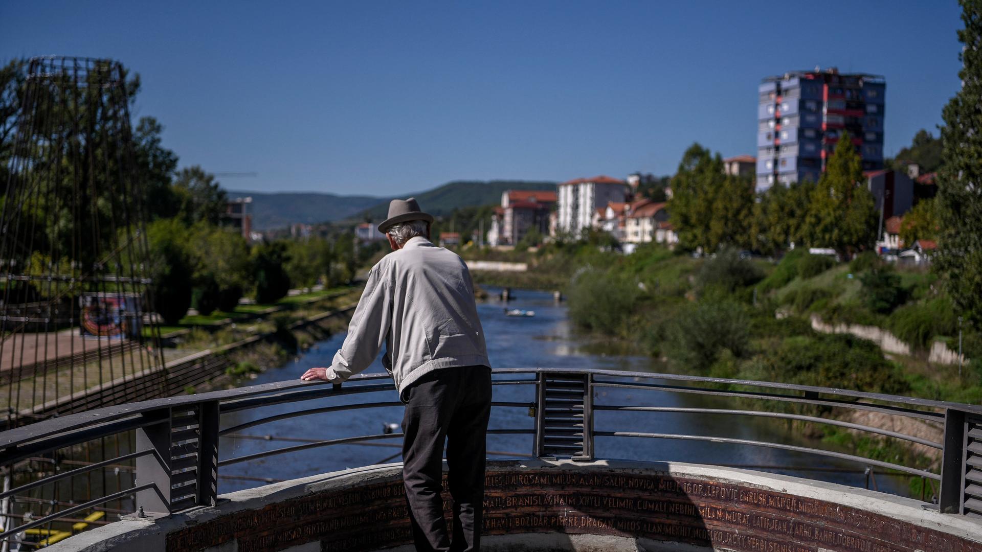 Ein kosovo-albanischer Mann blickt von einer Brücke in der tief geteilten Stadt Mitrovica Ein kosovo-albanischer Mann blickt von einer Brücke in der tief geteilten Stadt Mitrovica