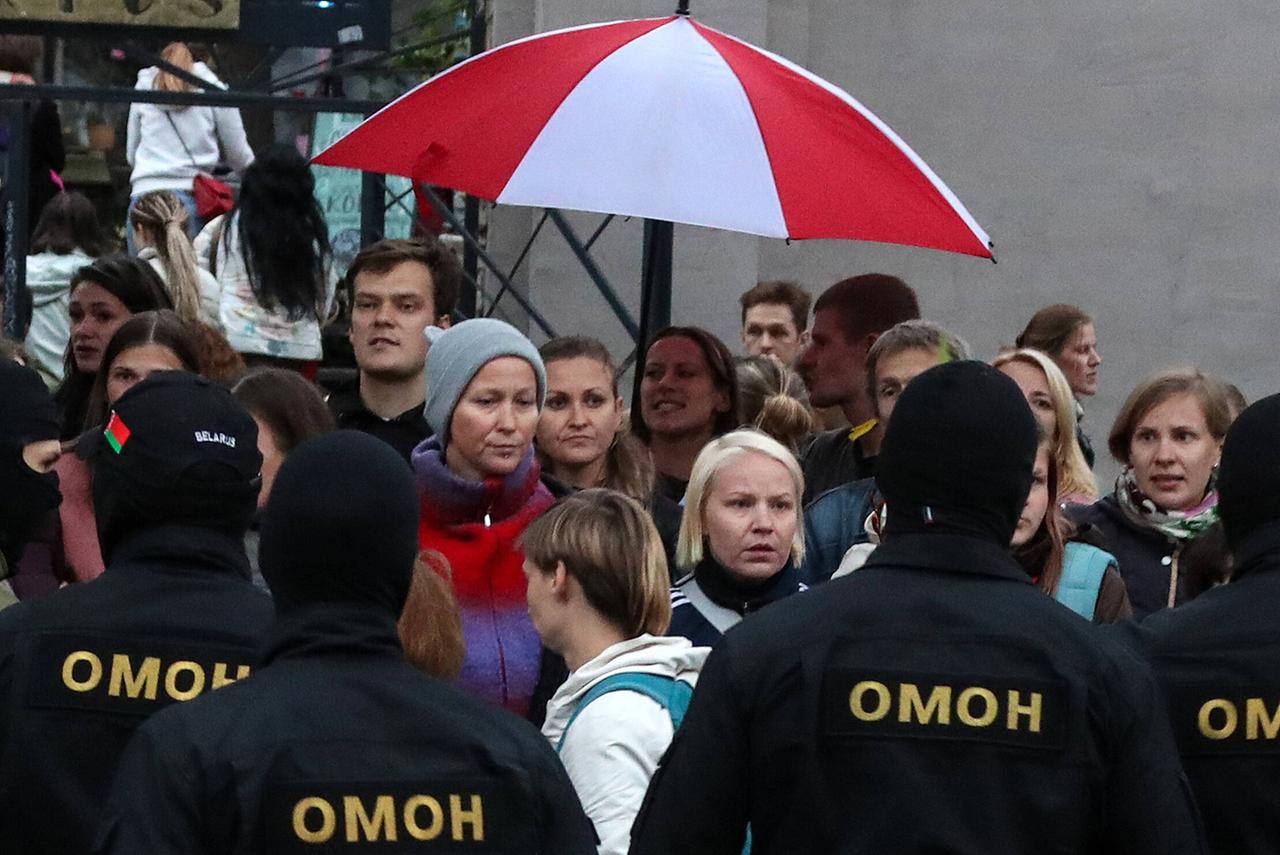 Omon-Polizisten bedrängen demonstrierende Frauen in Minsk am 08.09.2020, sie halten einen rotweißen Regenschirm über ihre Köpfe