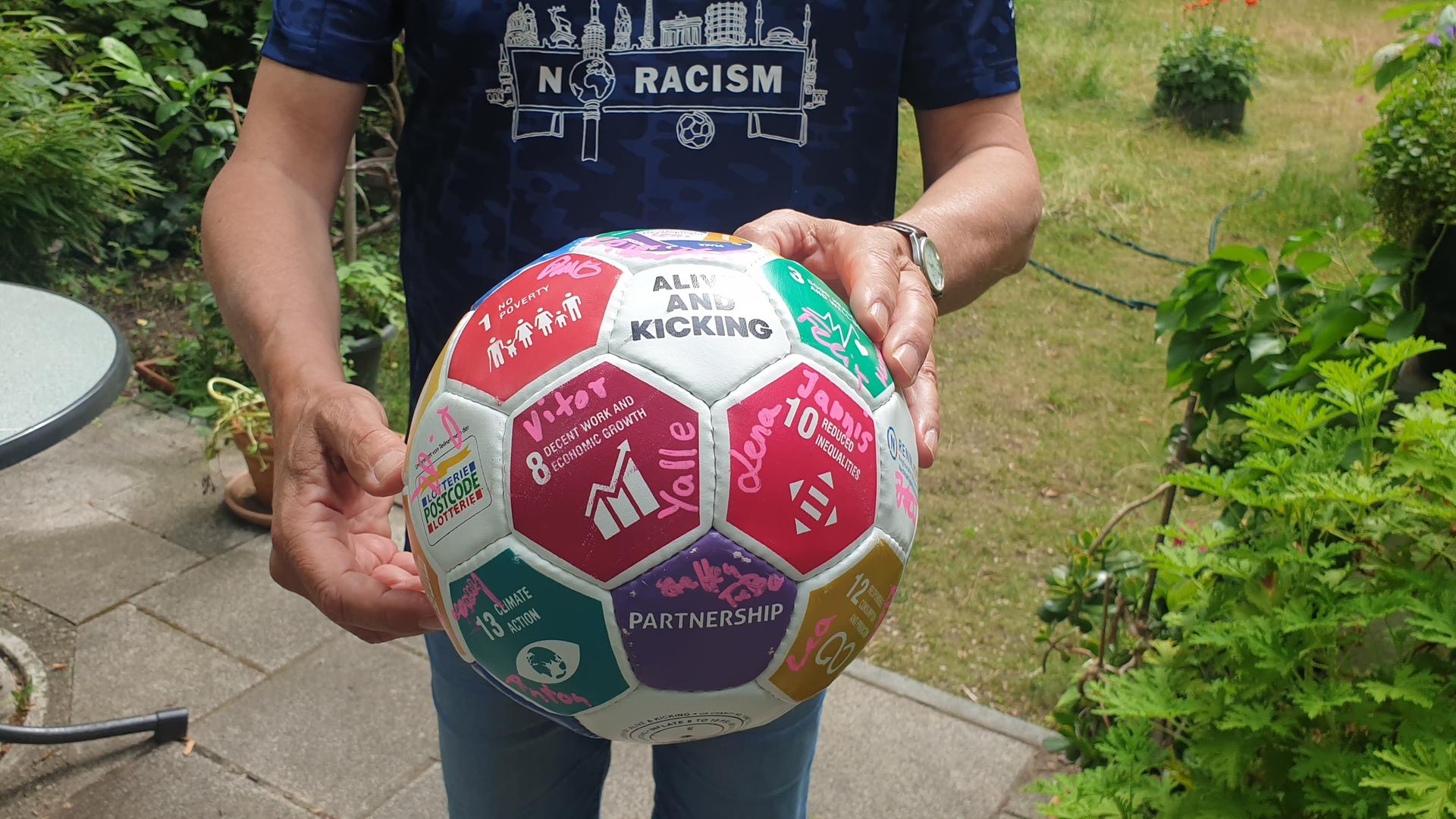 Oliver Brendle, Nachhaltigkeitsbeauftragter beim FC Internationale Berlin hält einen Fußball vor seinem Körper. Es ist nur seine Körpermitte zu sehen. Oliver Brendle, Nachhaltigkeitsbeauftragter beim FC Internationale Berlin hält einen Fußball vor seinem Körper. Es ist nur seine Körpermitte zu sehen.