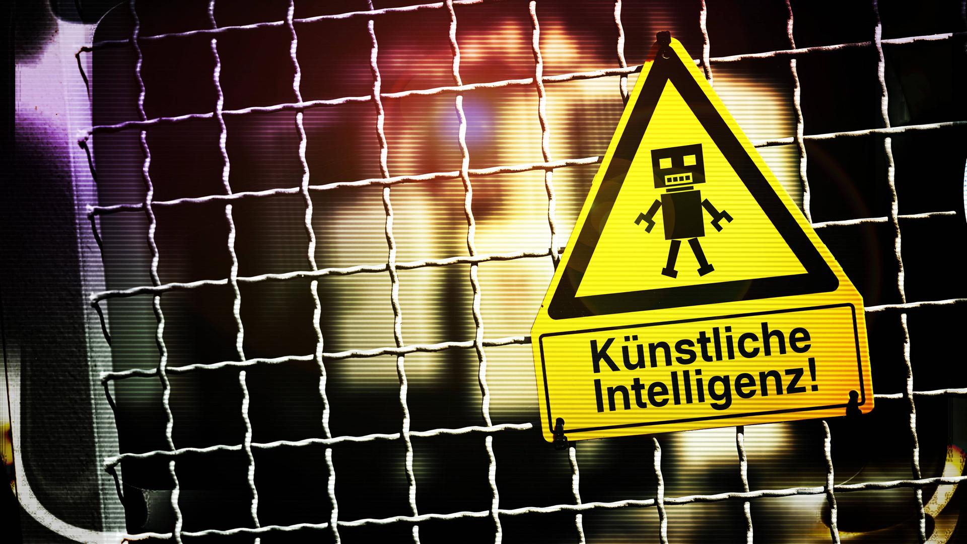Die Fotomontage zeigt eine Roboterfigur auf einem Warnschild mit der Aufschrift "Künstliche Intelligenz". Das Schild hängt an einem Zaun.