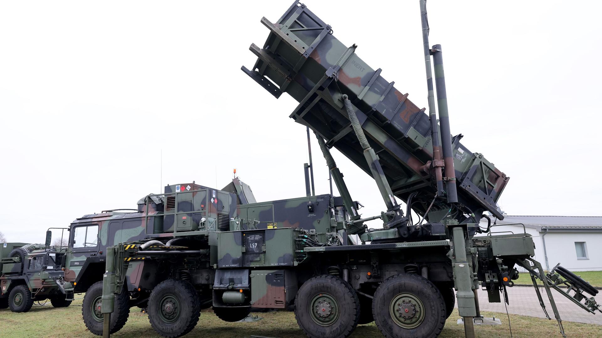 Zu sehen ist ein schwer gepanzertes Fahrzeug mit schräg aufgestellter Abschussrampe, welches zum Flugabwehrsystem Patriot gehört. Zu sehen ist ein schwer gepanzertes Fahrzeug mit schräg aufgestellter Abschussrampe, welches zum Flugabwehrsystem Patriot gehört.