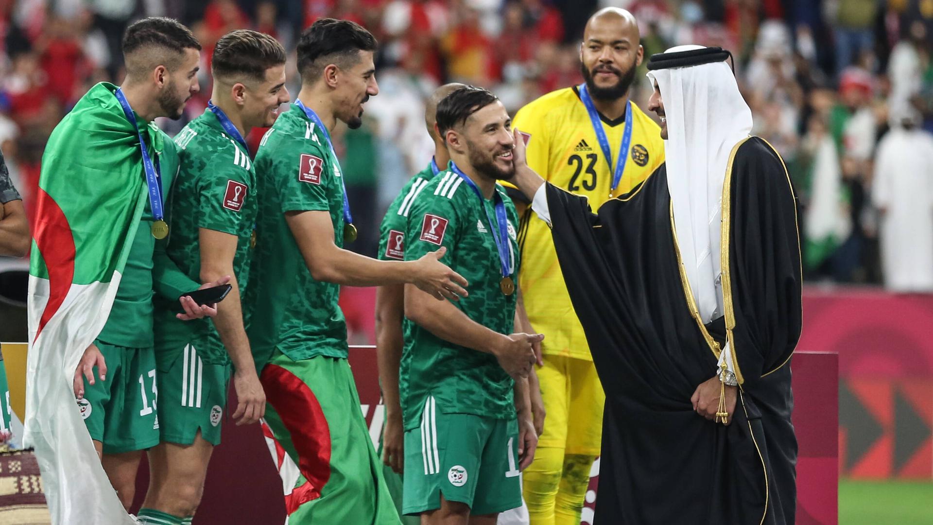 Scheich Tamim bin Hamad Al Thani, der Emir von Katar tätschelt die Wange des algerischen Spielers Mohammed Balaili. Scheich Tamim bin Hamad Al Thani, der Emir von Katar tätschelt die Wange des algerischen Spielers Mohammed Balaili.