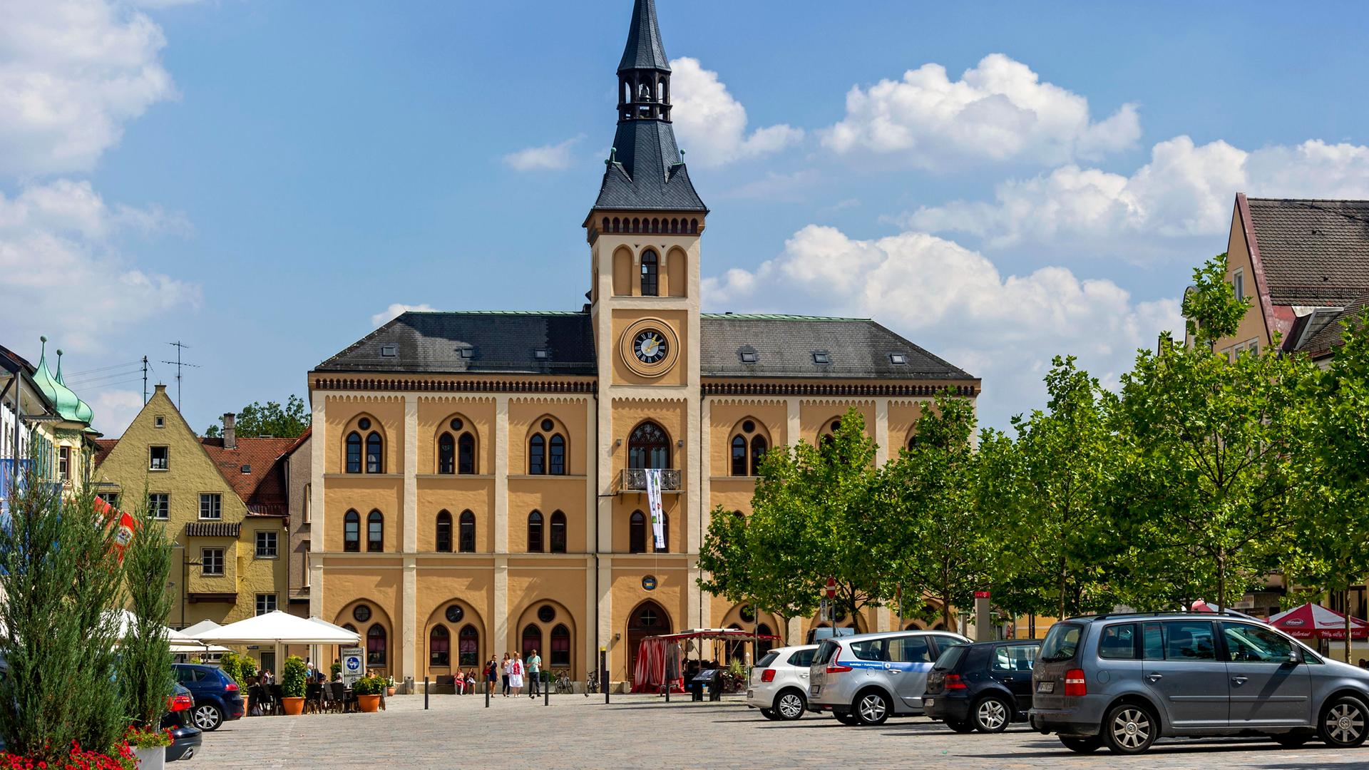 Das Rathaus am Unteren Hauptplatz in Pfaffenhofen an der Ilm in Oberbayern. Im Vordergrund parken Autos.