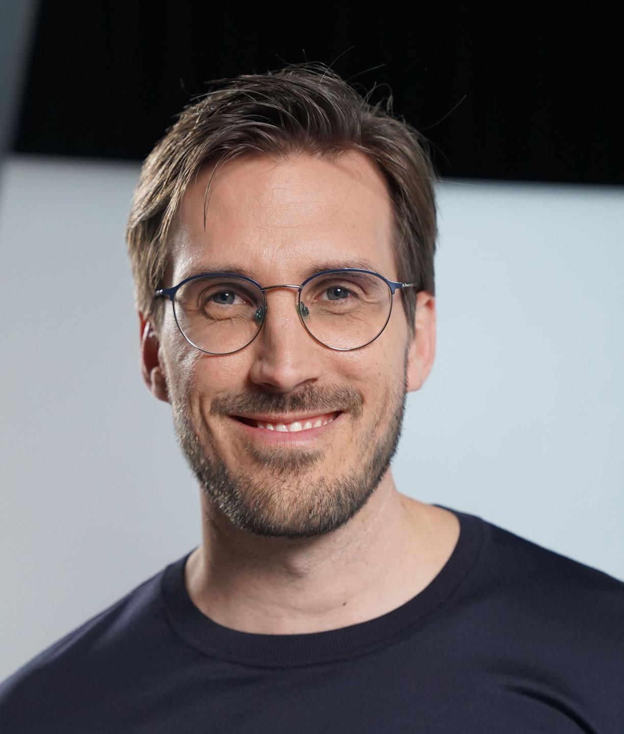 Der Philosoph Yves Bossart lächelt in die Kamera - er hat kurze braune Haare, trägt einen kurzen Bart, eine Brille und ein dunkelblaues Shirt. Der Philosoph Yves Bossart lächelt in die Kamera - er hat kurze braune Haare, trägt einen kurzen Bart, eine Brille und ein dunkelblaues Shirt.
