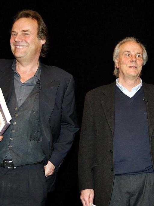 Die Schriftsteller Peter Schneider (links) und Hans Christoph Buch bei einer Veranstaltung mit dem damaligen Bundeskanzler Gerhard Schröder. 
