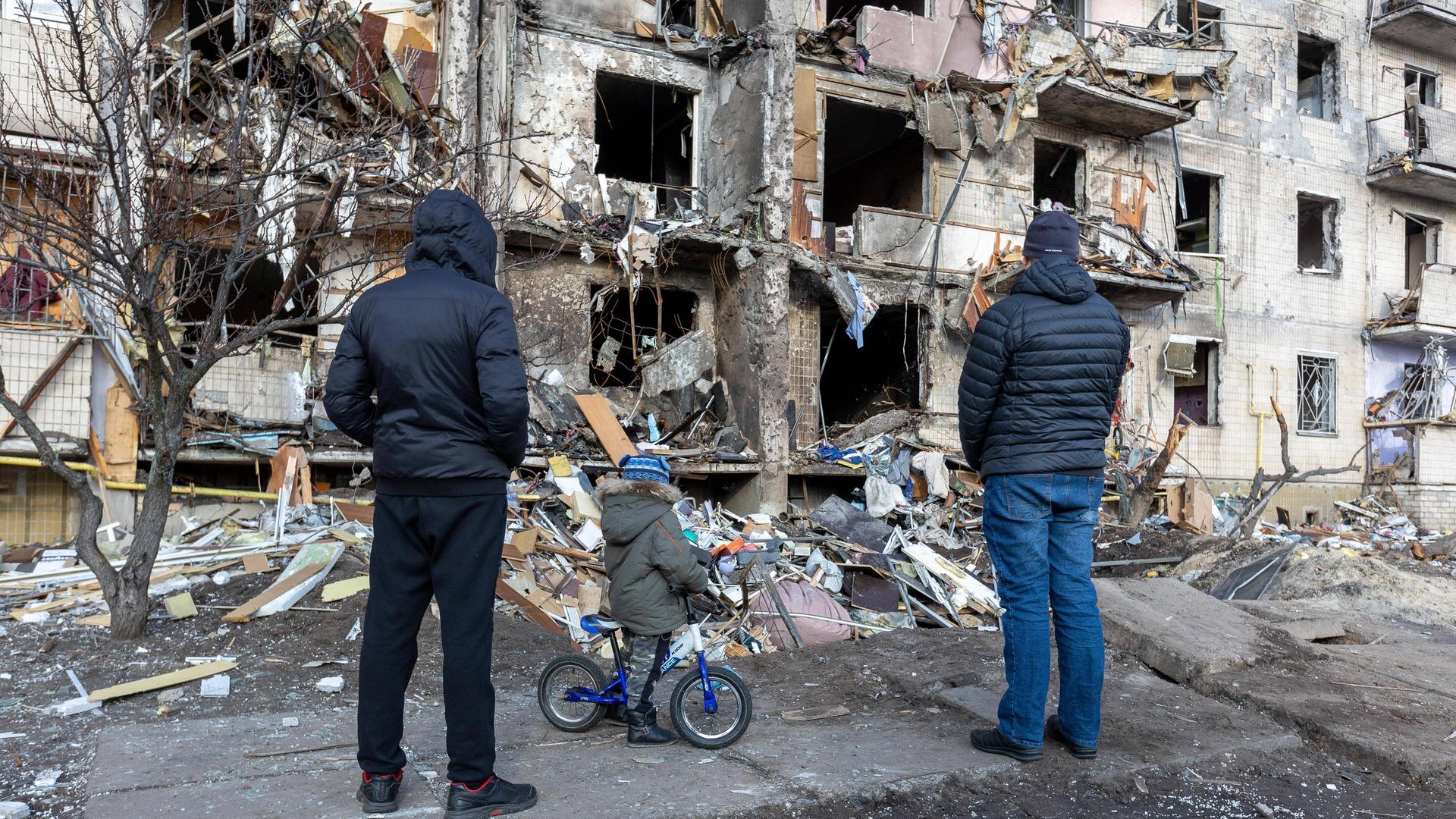 Ein zerstörtes Gebäude in Kiew nach einem russischen Bombenangriff. Menschen stehen vor dem Gebäude. Ein zerstörtes Gebäude in Kiew nach einem russischen Bombenangriff. Menschen stehen vor dem Gebäude.