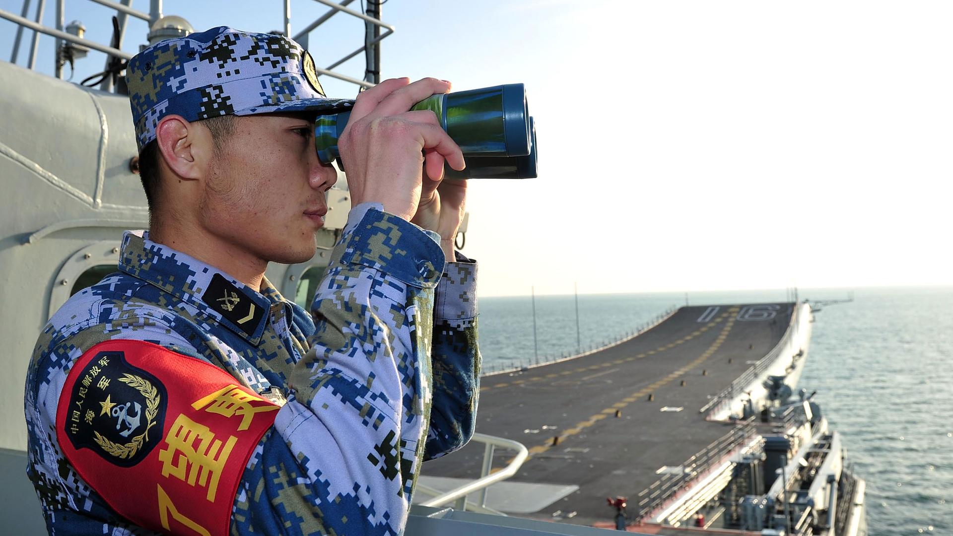 Ein Soldat mit Fernglas an Bord des chinesischen Flugzeugträgers Liaoning. Ein Soldat mit Fernglas an Bord des chinesischen Flugzeugträgers Liaoning.