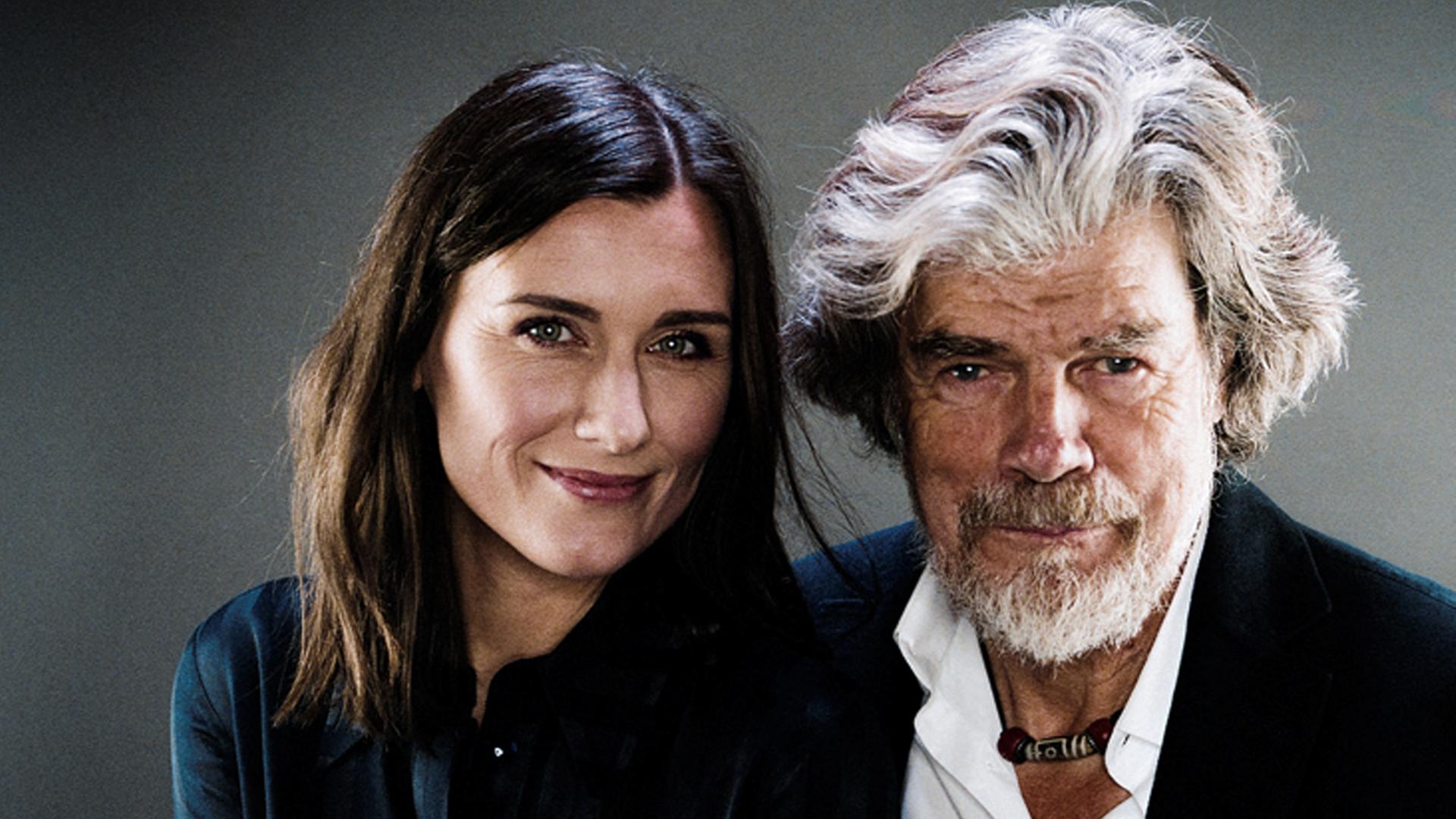 Diane Messner (links) und Reinhold Messner (rechts) sitzen vor einem grauen Hintergrund und schauen in die Kamera. Beide tragen dunkle Kleidung, Reinhold Messner allerdings ein weißes Hemd. Er hat weißer, welliges Haar und trägt Vollbart, seinen Arm hat er um Diane Messner gelegt. Diane Messner hat lange, dunkle Haare. Diane Messner (links) und Reinhold Messner (rechts) sitzen vor einem grauen Hintergrund und schauen in die Kamera. Beide tragen dunkle Kleidung, Reinhold Messner allerdings ein weißes Hemd. Er hat weißer, welliges Haar und trägt Vollbart, seinen Arm hat er um Diane Messner gelegt. Diane Messner hat lange, dunkle Haare.