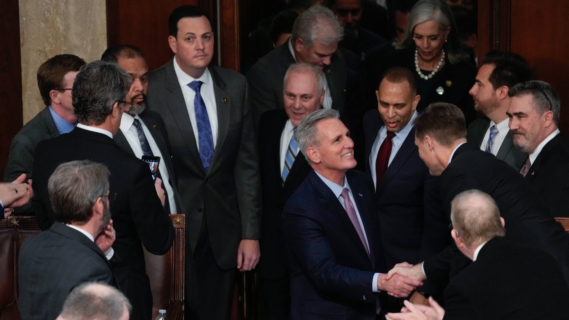 Der Republikaner Kevin McCarthy schüttelt lächelnd die Hände umstehender Mitglieder des US-Repräsentantenhauses. 