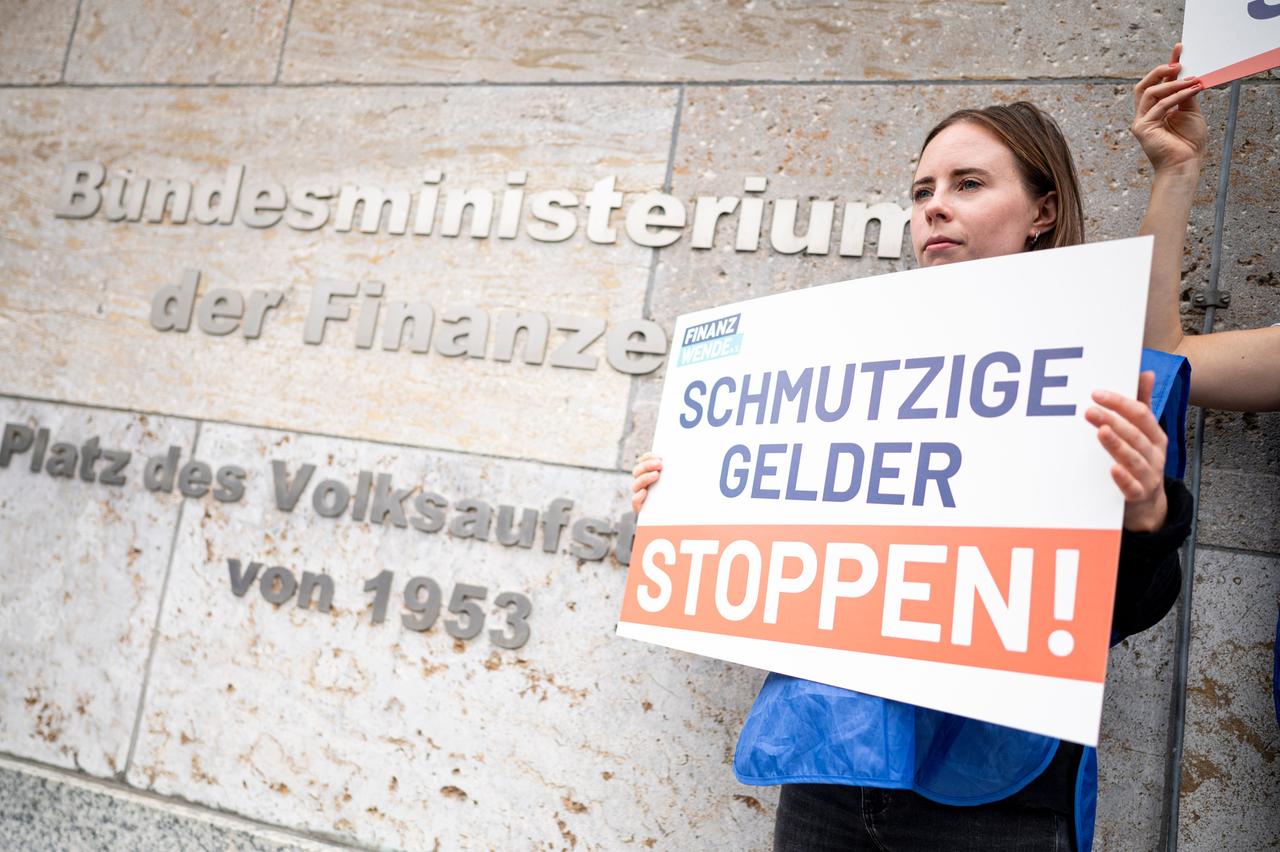 Eine Aktivistin der Bürgerbewegung Finanzwende protestiert vor dem Finanzministeriums mit einem Schild für stärkeres Vorgehen gegen schmutzige Gelder und Finanzkriminalität. Eine Aktivistin der Bürgerbewegung Finanzwende protestiert vor dem Finanzministeriums mit einem Schild für stärkeres Vorgehen gegen schmutzige Gelder und Finanzkriminalität.