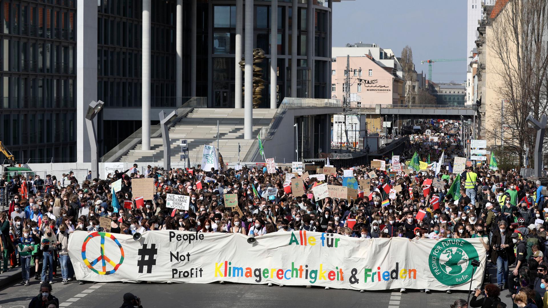 Ein Bild des vorherigen globalen Klimastreiks in Berlin. Tausende Menschen marschieren durch die Straßen. Sie tragen ein Banner mit ihren Forderungen. Ein Bild des vorherigen globalen Klimastreiks in Berlin. Tausende Menschen marschieren durch die Straßen. Sie tragen ein Banner mit ihren Forderungen.