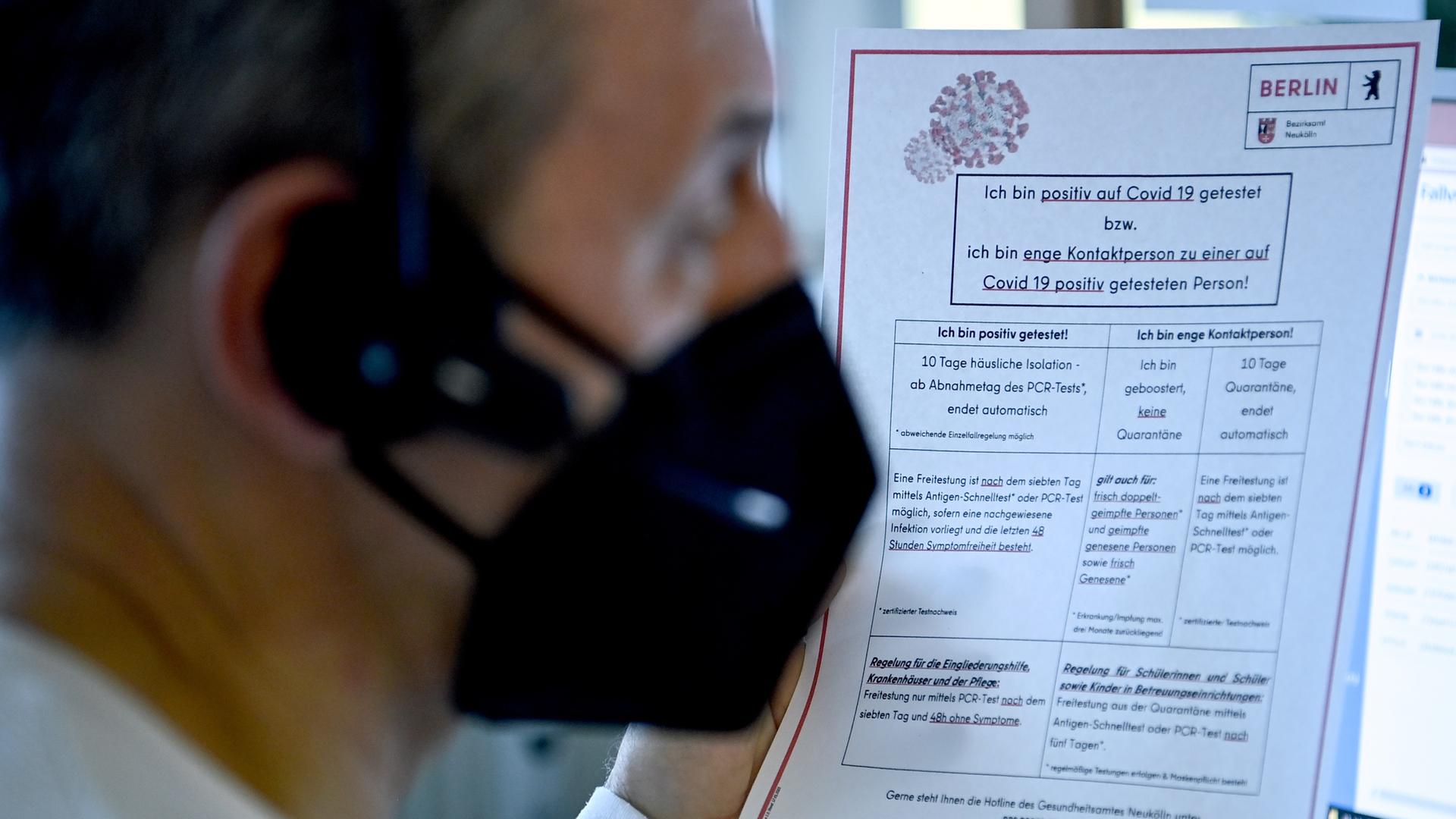 Ein Mitarbeiter sitzt am Telefon und beantwortet Fragen eines Anrufers an der Corona-Hotline. In der Hand hält er einen Leitfaden zur aktuellen Verordnung. Ein Mitarbeiter sitzt am Telefon und beantwortet Fragen eines Anrufers an der Corona-Hotline. In der Hand hält er einen Leitfaden zur aktuellen Verordnung.