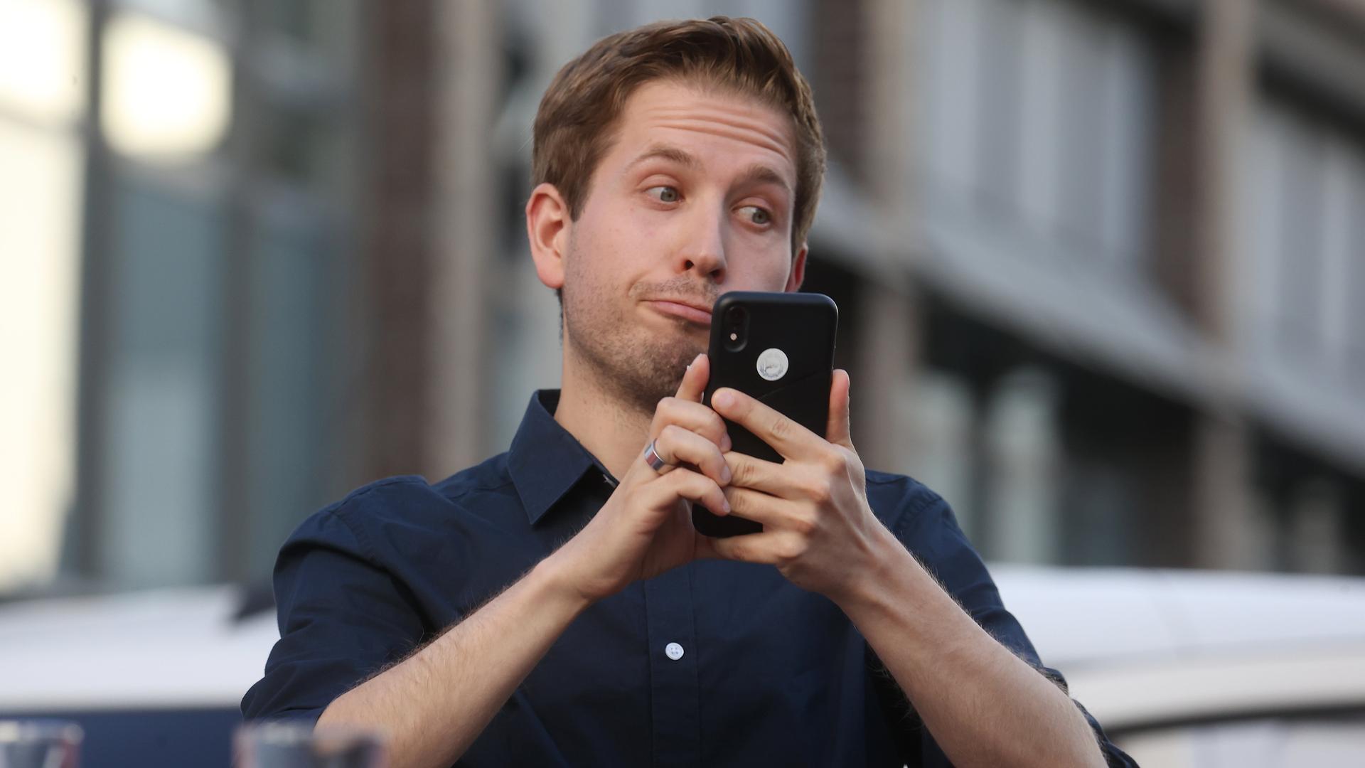 Kevin Kühnert (SPD) schaut auf sein Handy und verdreht die Augen. Kevin Kühnert (SPD) schaut auf sein Handy und verdreht die Augen.
