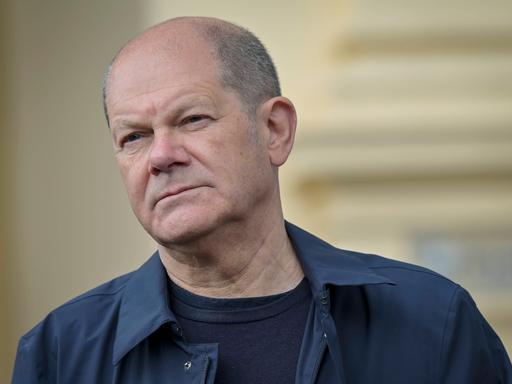 Porträt von Bundeskanzler Olaf Scholz mit schräg gehaltenem Kopf und leicht zusammengekniffenen Augen, 2022.