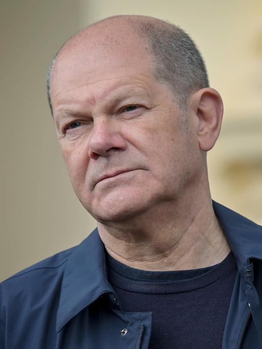 Porträt von Bundeskanzler Olaf Scholz mit schräg gehaltenem Kopf und leicht zusammengekniffenen Augen, 2022.