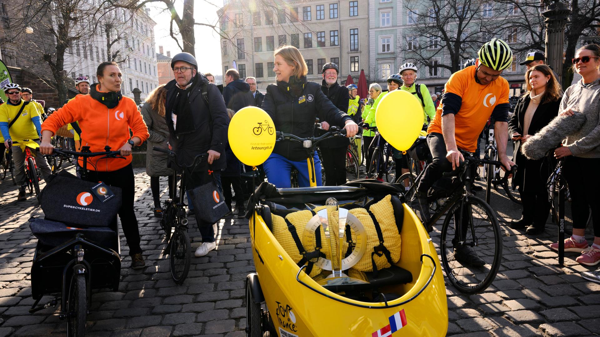Kopenhagens Bürgermeisterin fährt die Tour-de-France-Trophäe in einem Lastenrad durch die Stadt und wird von vielen Fahrradfahrern begleitet. Kopenhagens Bürgermeisterin fährt die Tour-de-France-Trophäe in einem Lastenrad durch die Stadt und wird von vielen Fahrradfahrern begleitet.