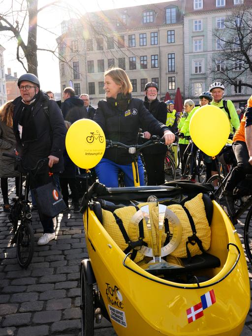 Kopenhagens Bürgermeisterin fährt die Tour-de-France-Trophäe in einem Lastenrad durch die Stadt und wird von vielen Fahrradfahrern begleitet.