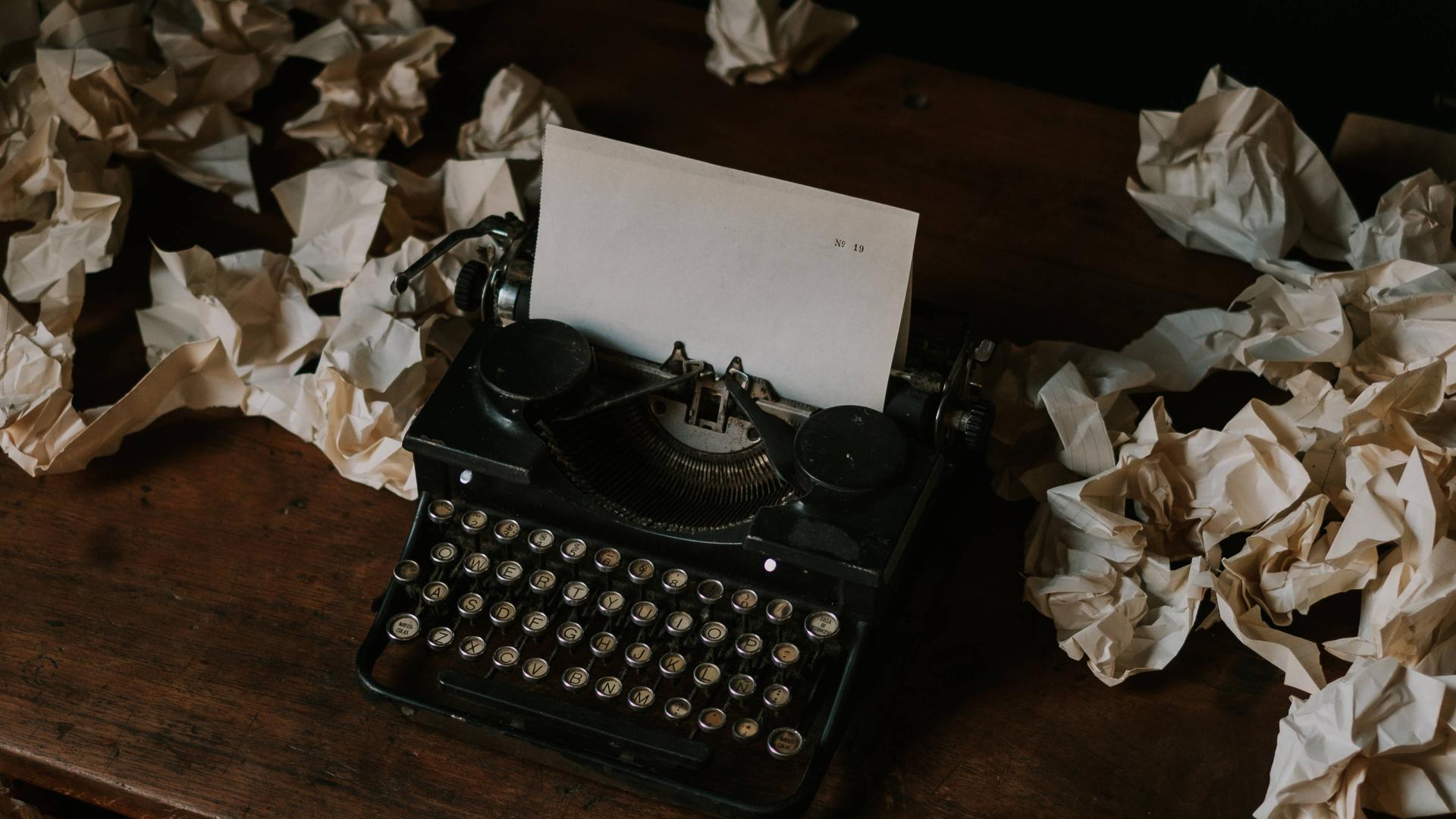 Das Foto zeigt eine Schreib-Maschine mit einem leeren Blatt Papier.