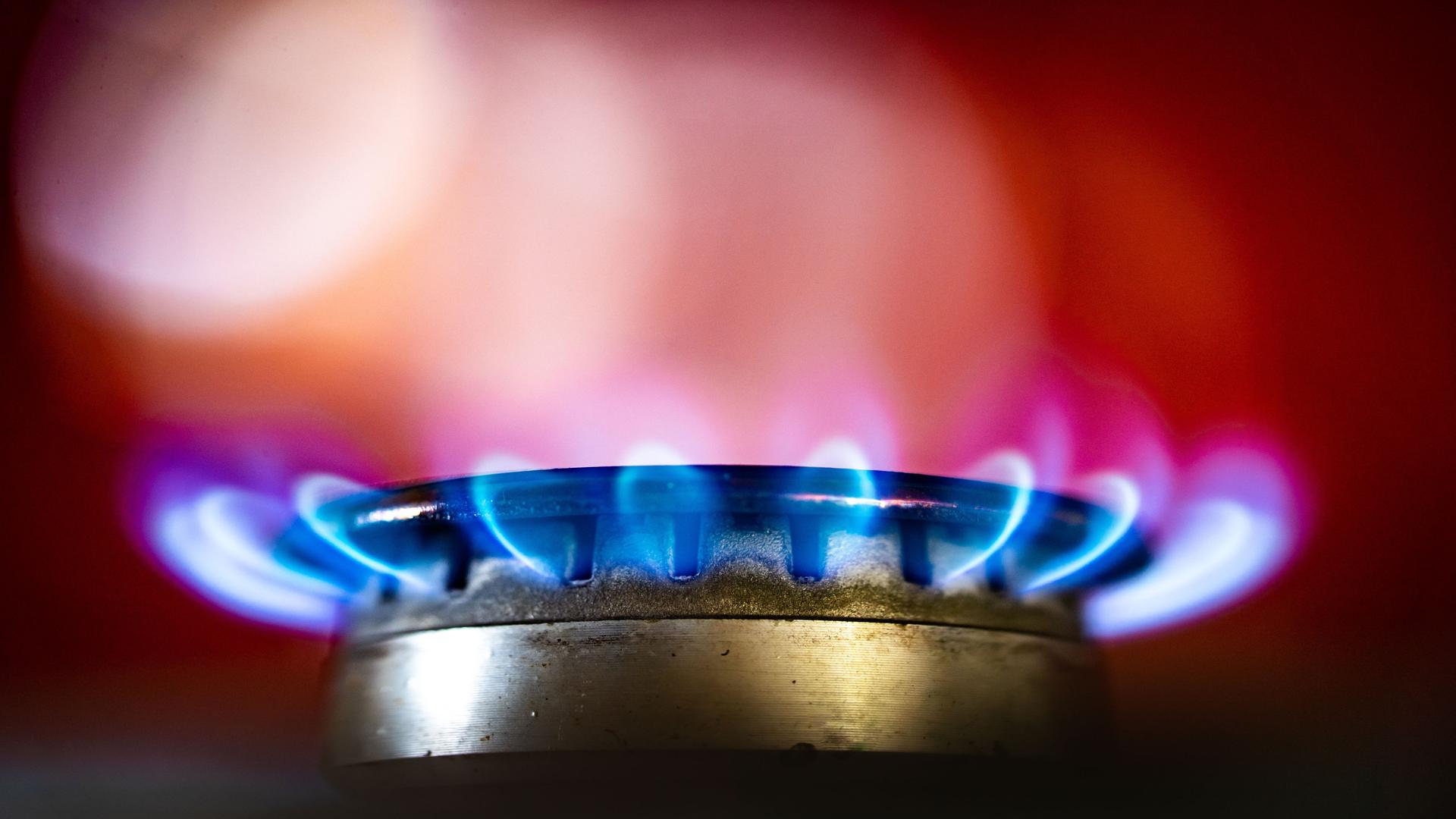 Die Flamme eines Gasherdes brennt in einer Küche. Die Flamme eines Gasherdes brennt in einer Küche.