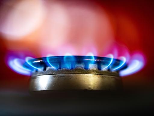 Die Flamme eines Gasherdes brennt in einer Küche.