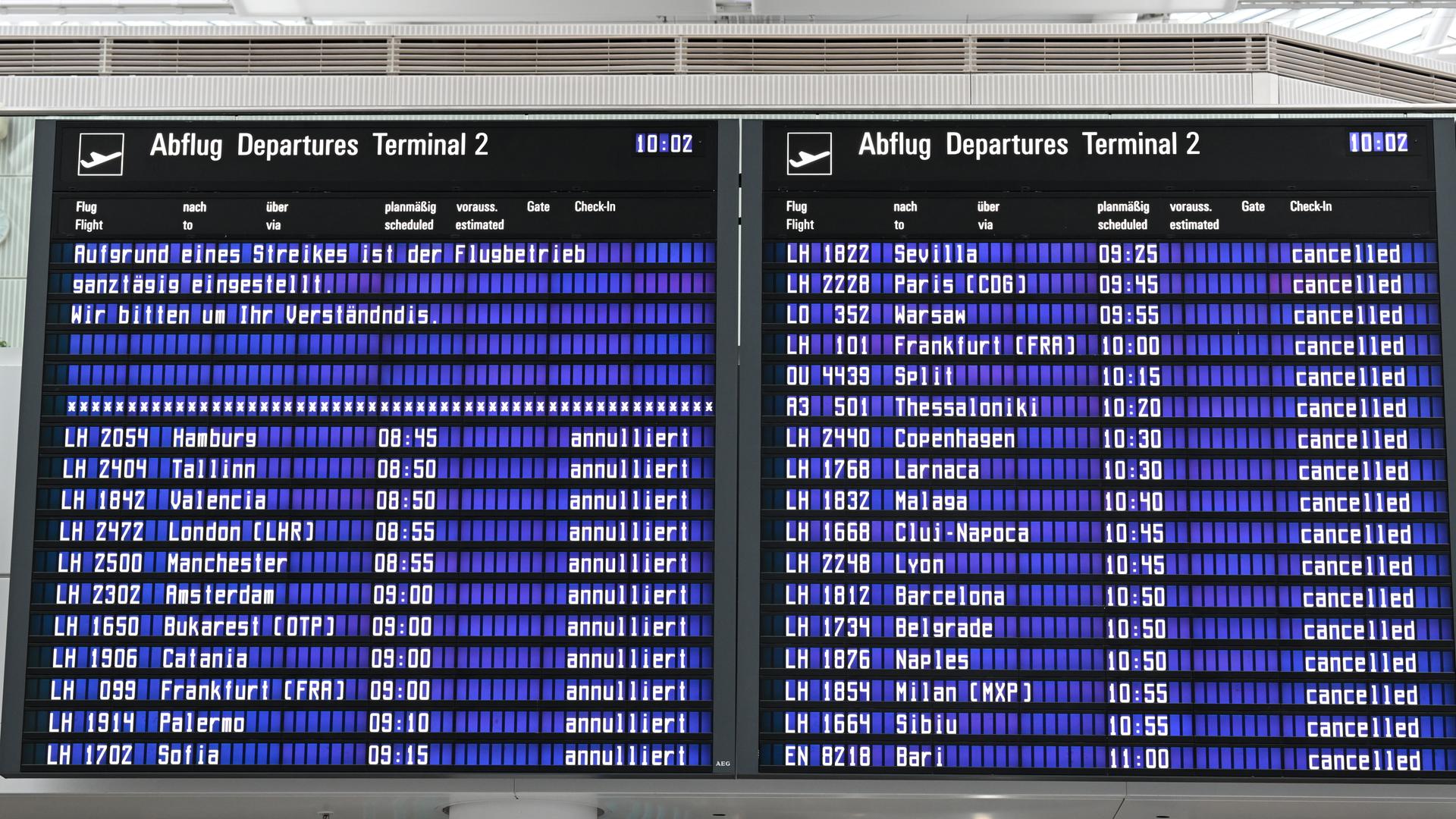 Auf einer Anzeigentafel wird im Münchner Flughafen auf den Streik hingewiesen.