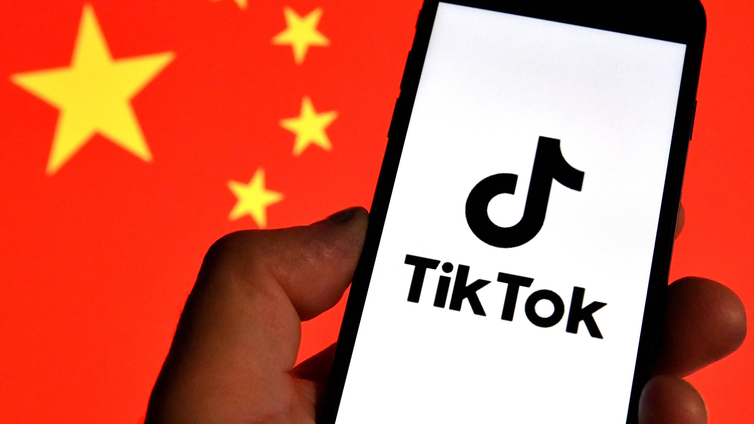 TikTok-Logo auf einem Handy vor chinesischer Nationalflagge
