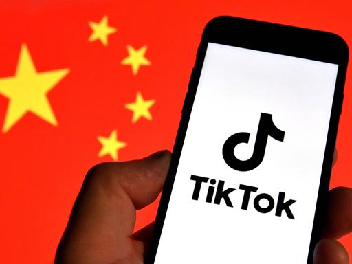 TikTok-Logo auf einem Handy vor chinesischer Nationalflagge