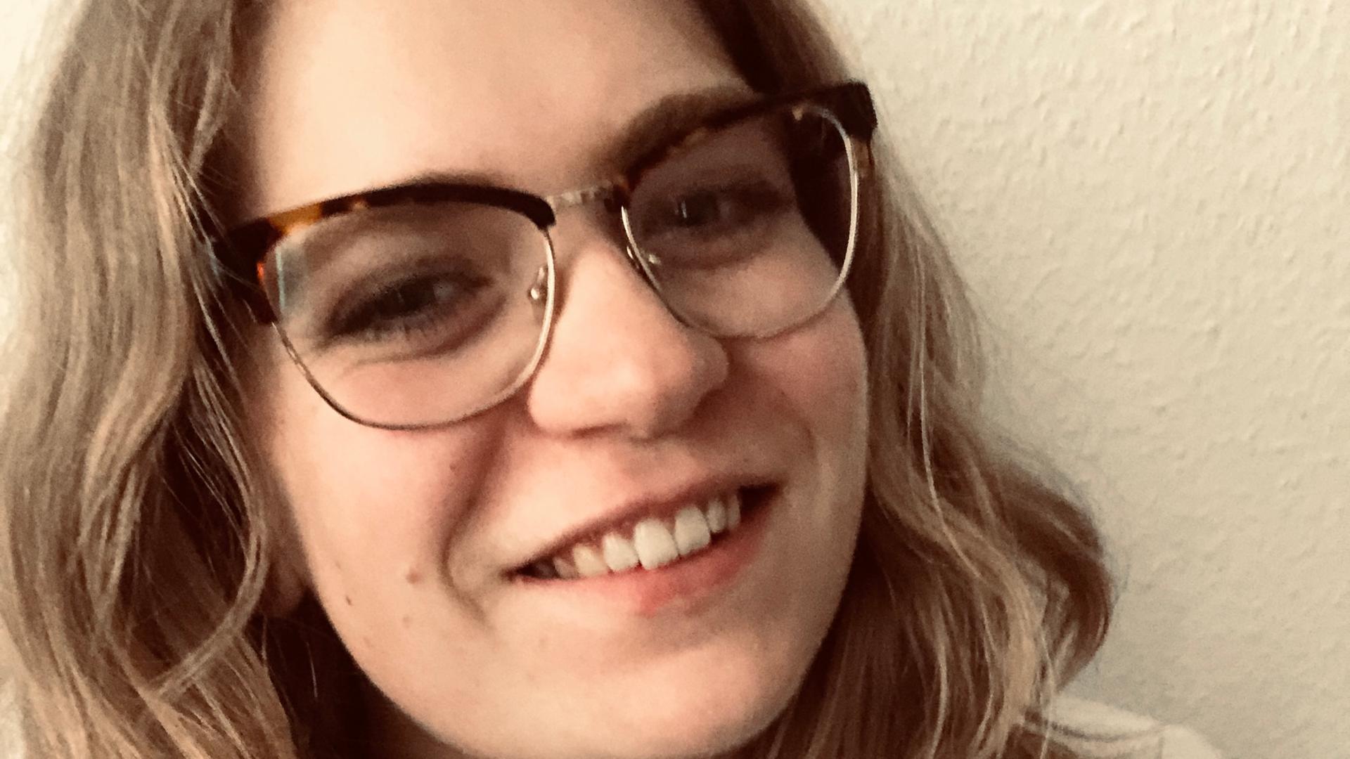 Porträt von Annemarie. Sie trägt eine Brille und lächelt in die Kamera. Porträt von Annemarie. Sie trägt eine Brille und lächelt in die Kamera.