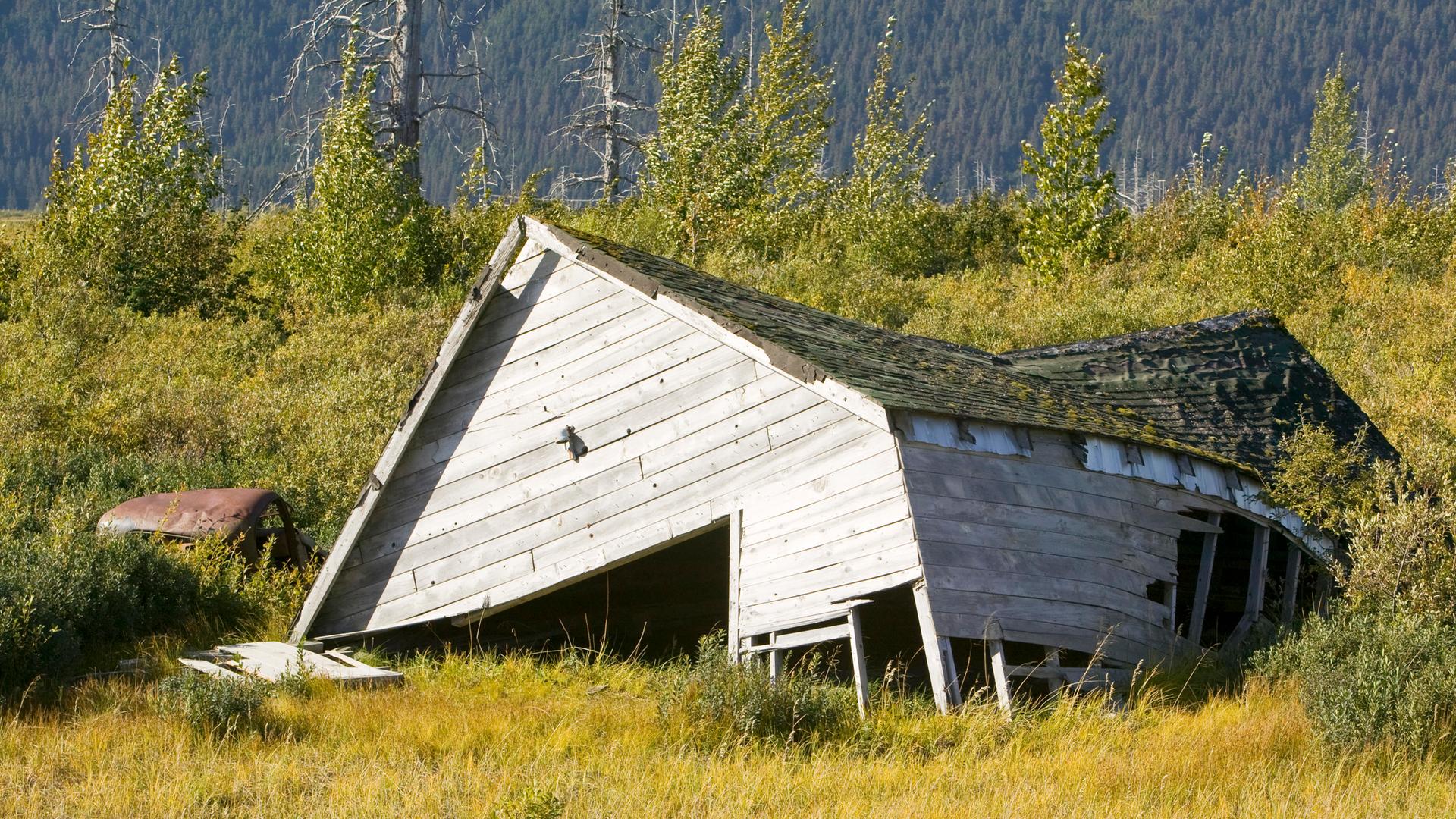 Eine Holzhütte in Alaska ist auf dem aufgetauten Boden in sich zusammengefallen und nicht mehr bewohnbar. Eine Holzhütte in Alaska ist auf dem aufgetauten Boden in sich zusammengefallen und nicht mehr bewohnbar.